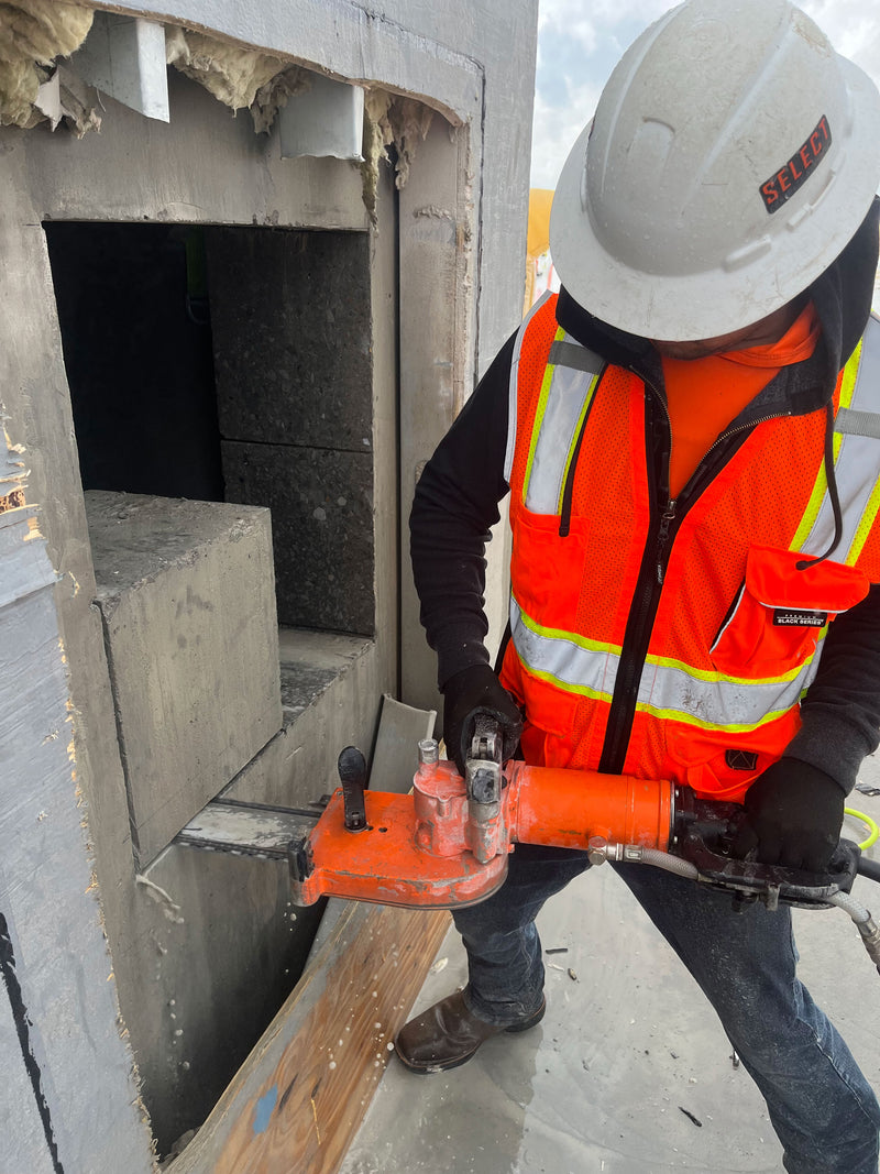 Select Concrete Services worker cutting a block of concrete with an electric saw