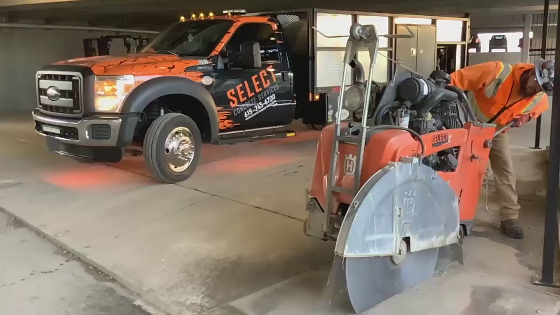 A video of a man cutting a slab of concrete with a giant saw 